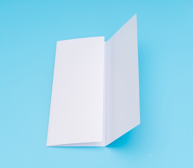 Trifold white template paper on blue background .