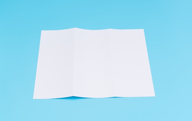 Free photo trifold white template paper on blue background .