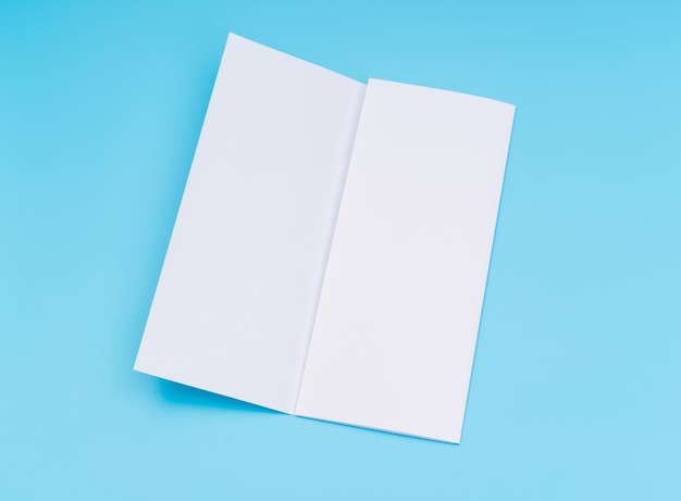 Free photo trifold white template paper on blue background .