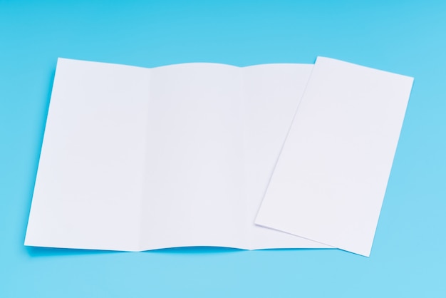 Trifold white template paper on blue background .