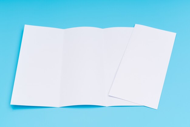 Trifold white template paper on blue background .