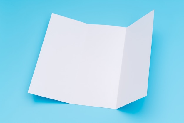 Бесплатное фото Трифоновый белый шаблон бумаги на синем фоне.
