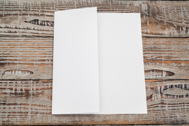 Trifold white template paper on wood texture .