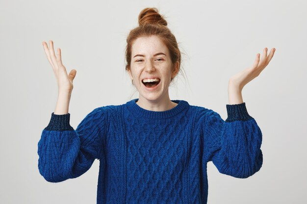 Triumphing cute redhead girl celebrate achievement, shouting yes