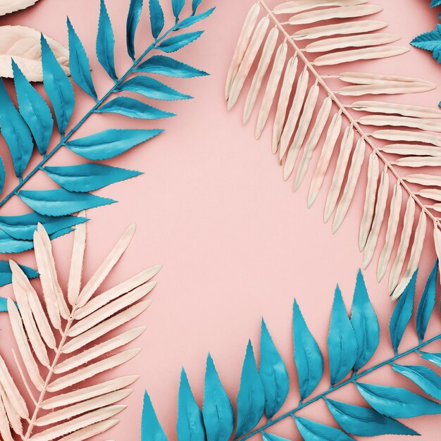 Tropical blue and pink palm leaves on pink background