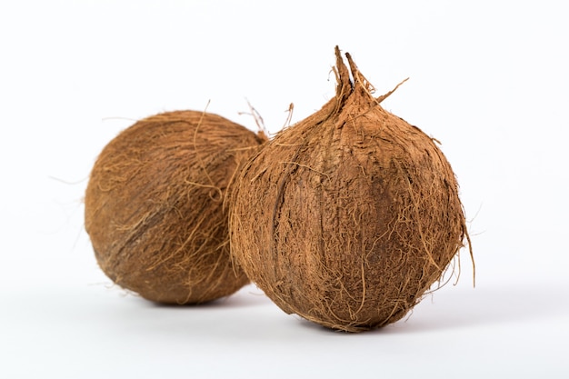 Free photo tropical fruits brown yummy mellow juicy coconuts isolated on a white desk