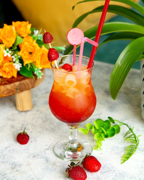 Tropical juice with lots of ice and strawberries on it