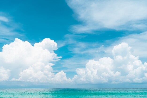 熱帯の自然のきれいなビーチと夏の白い砂と太陽の光の青い空と背景のボケ味 プレミアム写真