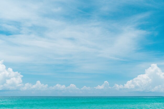 熱帯の自然のきれいなビーチと夏の白い砂と太陽の光の青い空と背景のボケ味 プレミアム写真