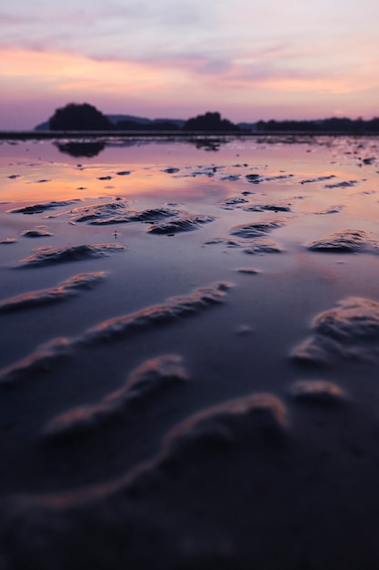 Foto gratuita spiaggia di sabbia tropicale con cielo drammatico con la bassa marea