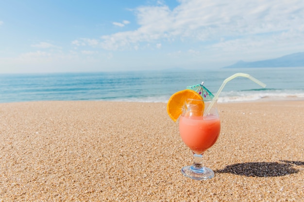 Бесплатное фото Тропический коктейль в стекле на песке
