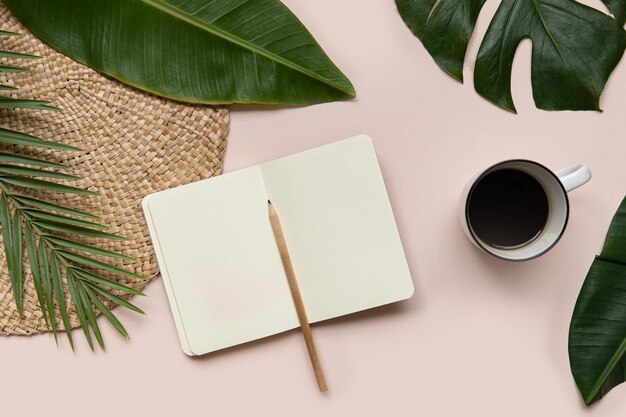 Tropical workspace concept Notepad and tropical palm leaves Mockup presentation workplace