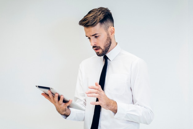 Free photo troubled man looking at a tablet