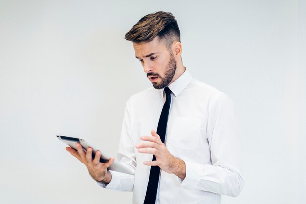 Troubled man looking at a tablet