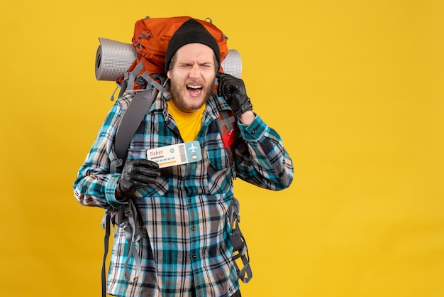 troubled young backpacker with black hat holding plane ticket and ear