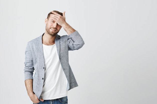 Free photo troubled young man facepalm and look bothered