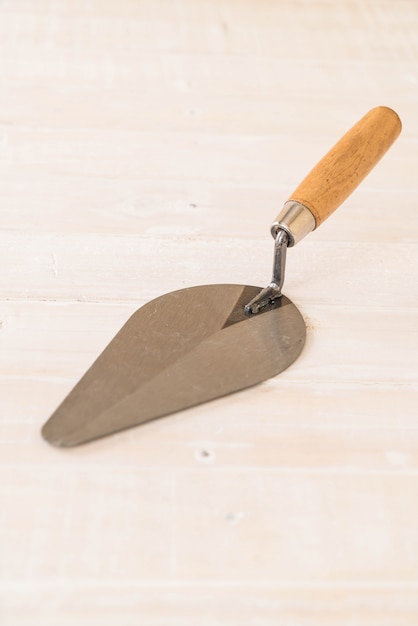 Free photo trowel the mortar on wood