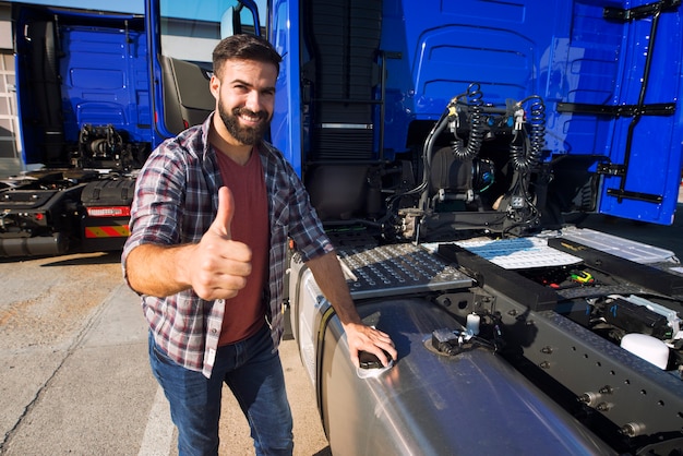 Free photo truck driver opening reservoir tank to refuel the truck and holding thumbs up