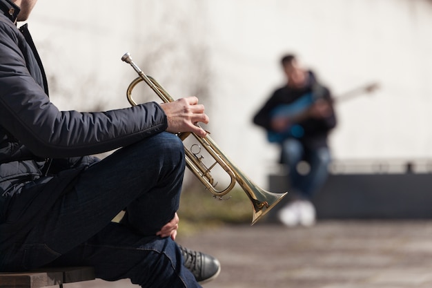 Free photo trumpet player and blurred guitarist