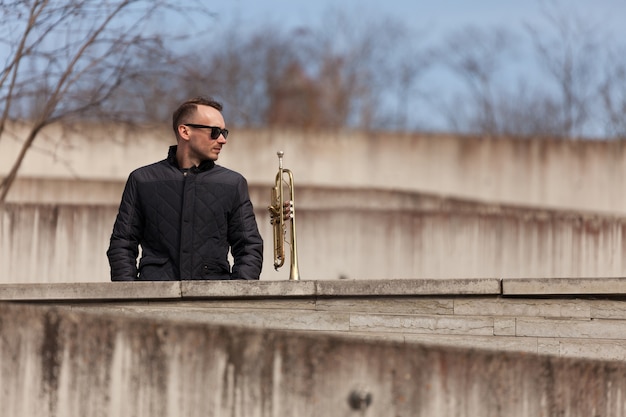 Free photo trumpet player standing in urban environment