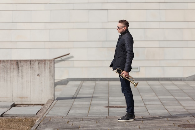 Trumpet player in urban environment side view