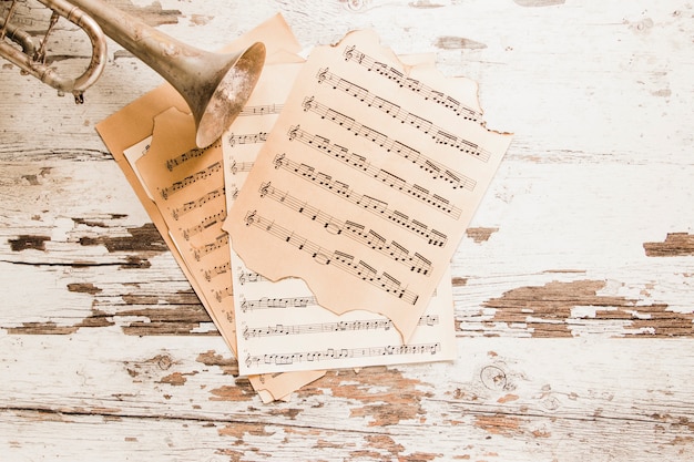 Trumpet and sheet music on old table