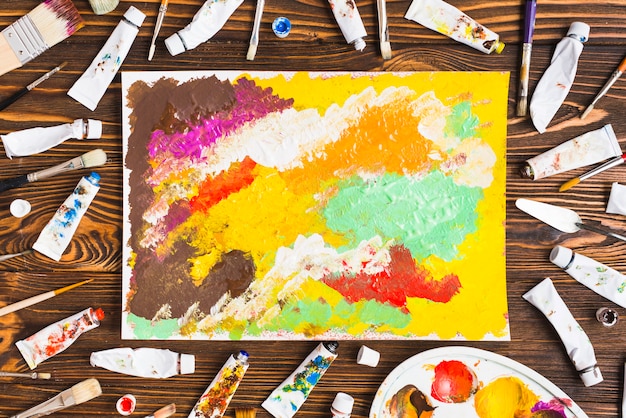 Free photo tubes and brushes around abstract painting