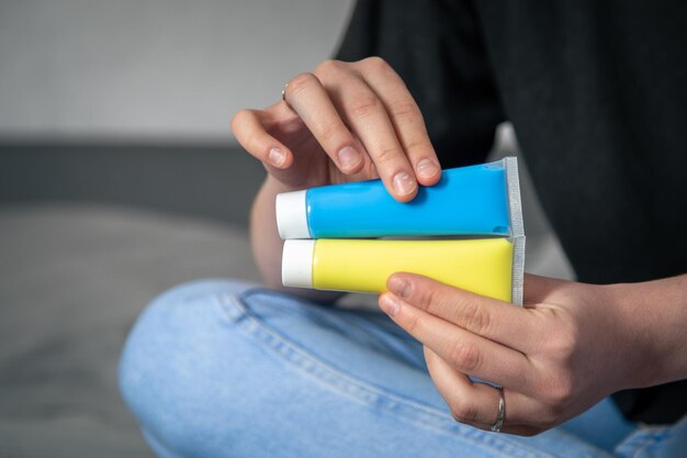 Tubes of yellow and blue paint in female hands the flag of ukraine