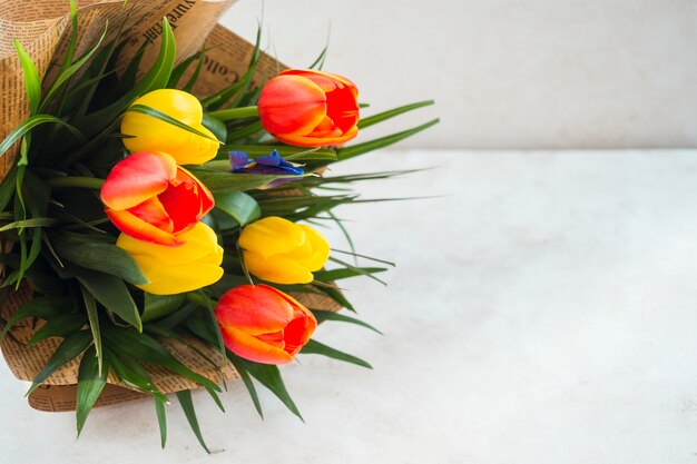 Tulip flowers bouquet in pack paper on table 