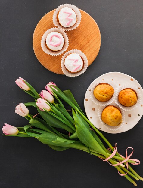 テーブルの上のカップケーキとチューリップの花