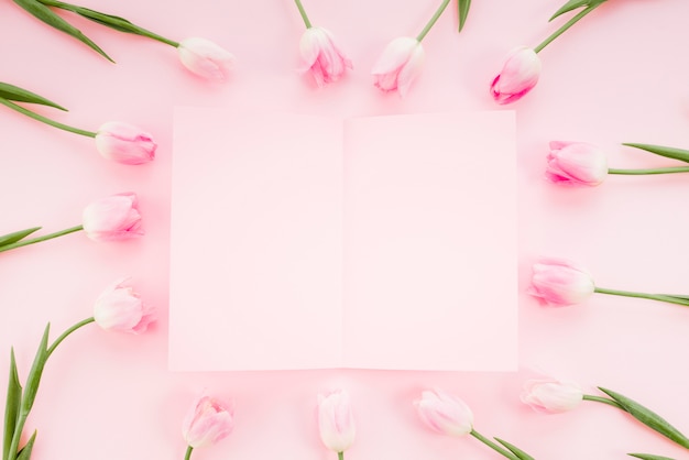 Free photo tulip flowers with paper on table