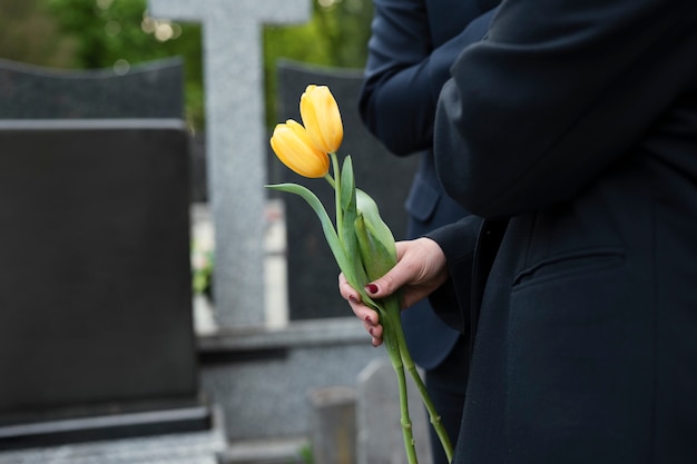 Free photo tulips being brought to a grave at the cemetery