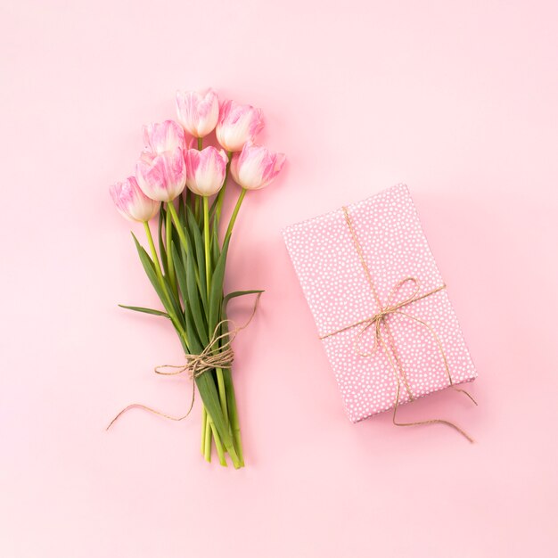 Tulips bouquet with gift box on table