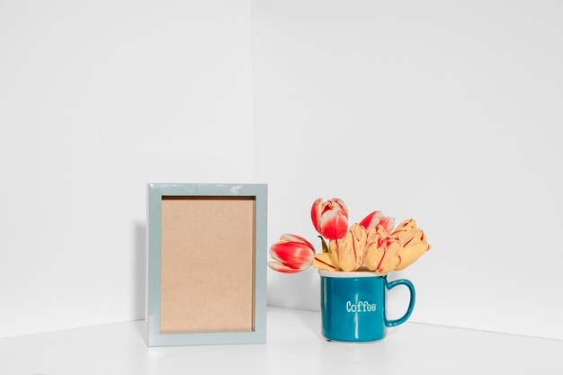 Tulips in mug near frame