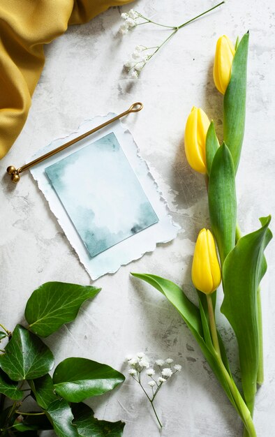 Tulips with greeting card on table