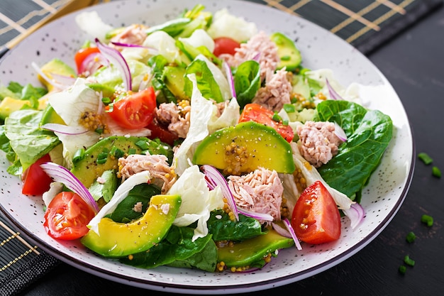 Салат из тунца с листьями салата, помидорами черри, авокадо и красным луком. Здоровая пища. Французская кухня.