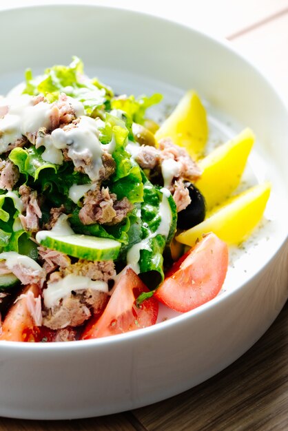 Tuna salad with cucumbers tomatoes olives and lettuce