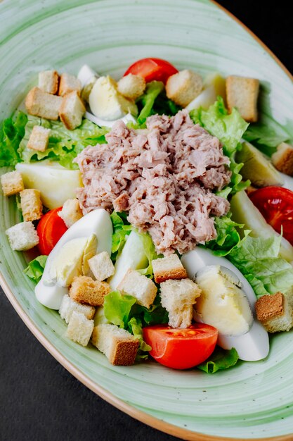 Tuna salad with eggs tomatoes lettuce and crackers