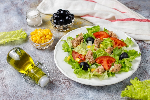 Tuna salad with lettuce,olives,corn,tomatoes,top view