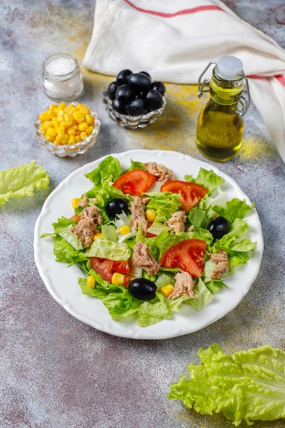 Tuna salad with lettuce,olives,corn,tomatoes,top view