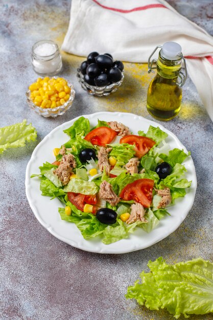 Tuna salad with lettuce,olives,corn,tomatoes,top view