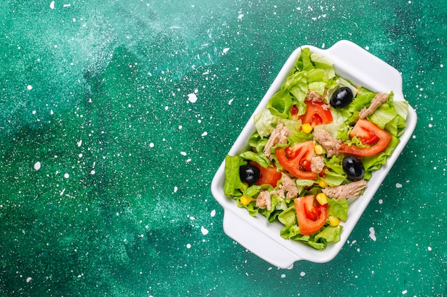 Бесплатное фото Салат из тунца с листьями салата, маслинами, кукурузой, помидорами, вид сверху