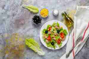 Free photo tuna salad with lettuce,olives,corn,tomatoes,top view