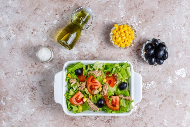 Бесплатное фото Салат из тунца с листьями салата, маслинами, кукурузой, помидорами, вид сверху