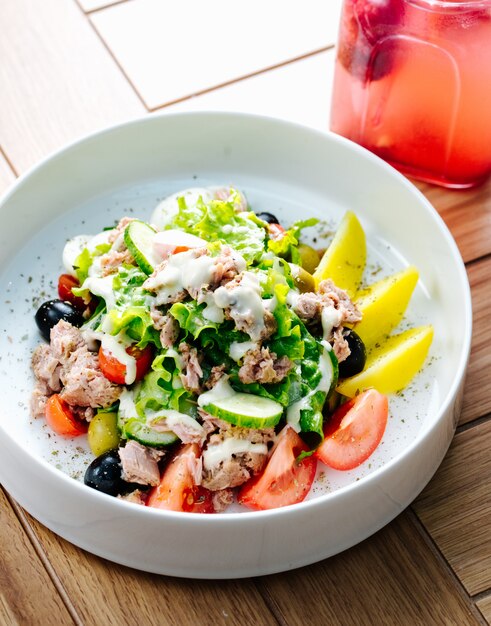 Салат из тунца с оливками, помидорами и листьями салата