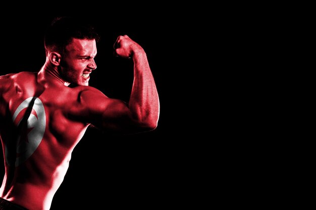 Tunisia flag on handsome young muscular man black background