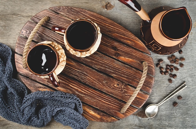 Турок и кофейные чашки на деревянном подносе. деревенский стиль