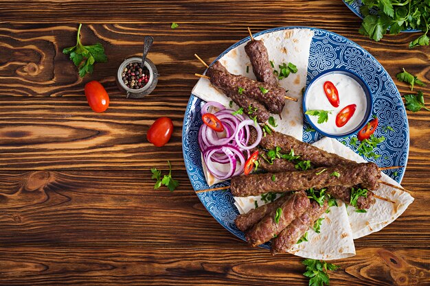 터키어와 아랍어 전통 라마단 믹스 케밥 플레이트. 케밥 아다 나, 닭고기, 양고기 및 쇠고기와 소스와 함께 lavash 빵에. 평면도
