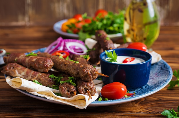 トルコとアラビアの伝統的なラマダンミックスケバブプレート。ケバブのアダナ、鶏肉、ラム肉、牛肉のラバッシュパンソース添え。上面図
