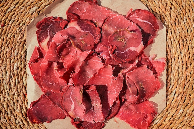 Turkish bacon pastrami or kayseri pastirma fresh sliced pastrami on a paper lining top view